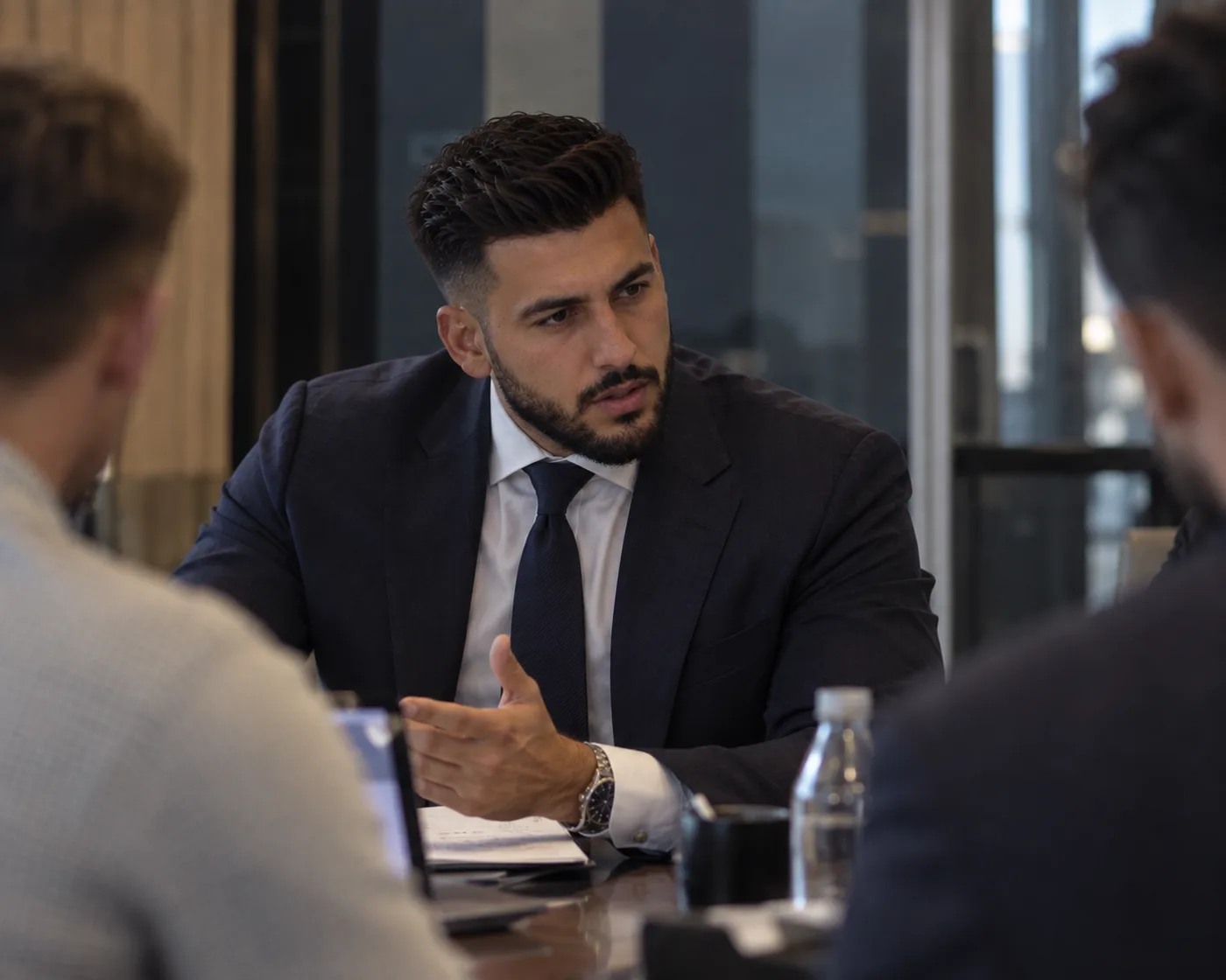 Ibrahim AbuShamala speaking with two people across a meeting table.